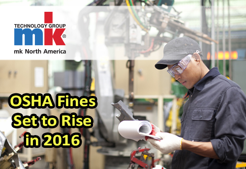 A shop worker reviewing machine guarding for OSHA compliance.